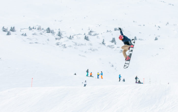 Ein junger Snowboarder springt über eine Schanze