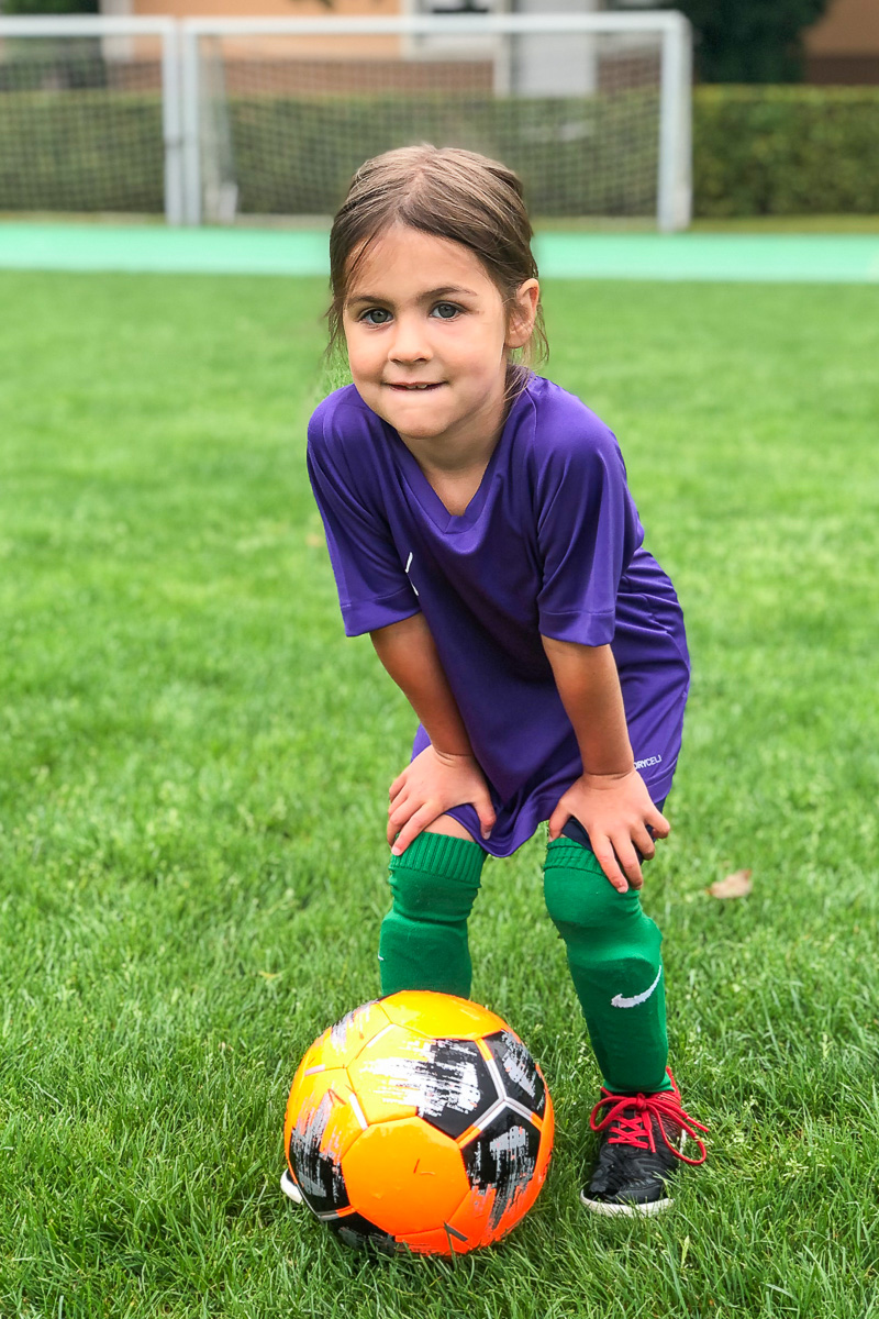 Eine junge Fussballerin posiert mit dem Ball