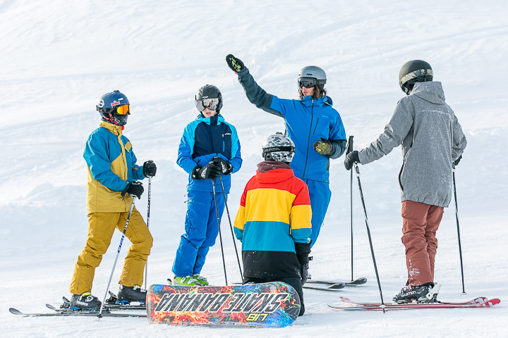 Ein Leiter erklärt vier Jugendlichen Ski- und Snowboardfahrern eine Übung im Jugendsportcamp des Kantons Aargau