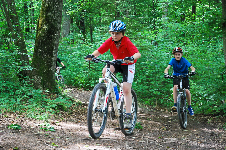 Zwei Jungs fahren auf dem Mountainbike durch den Wald